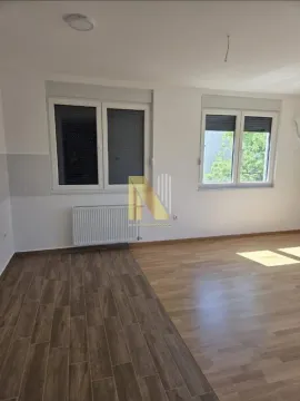 Prazna svetla prostorija sa prozorima i kombinovanim podom od pločica i laminata. - image 3