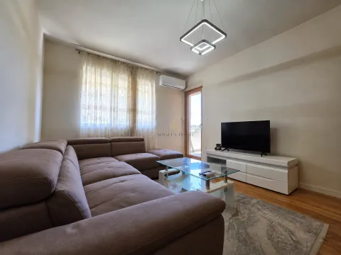 Living room with a sectional sofa, TV, and access to the balcony. - image 2