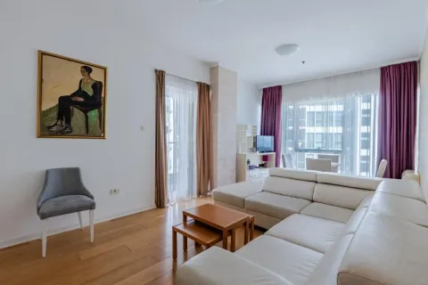 Bright living room with a sectional sofa, wooden coffee table, and large windows. - image 6