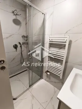 Modern bathroom with a shower cabin and white tiles. - image 21