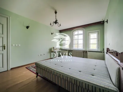 Spacious bedroom with light-colored walls, wooden flooring, and windows. - image 9