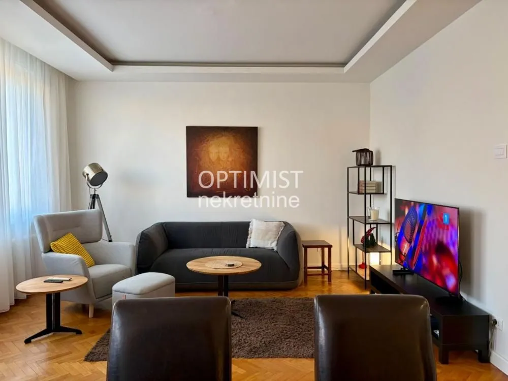 Living room with sofa, armchair and TV.