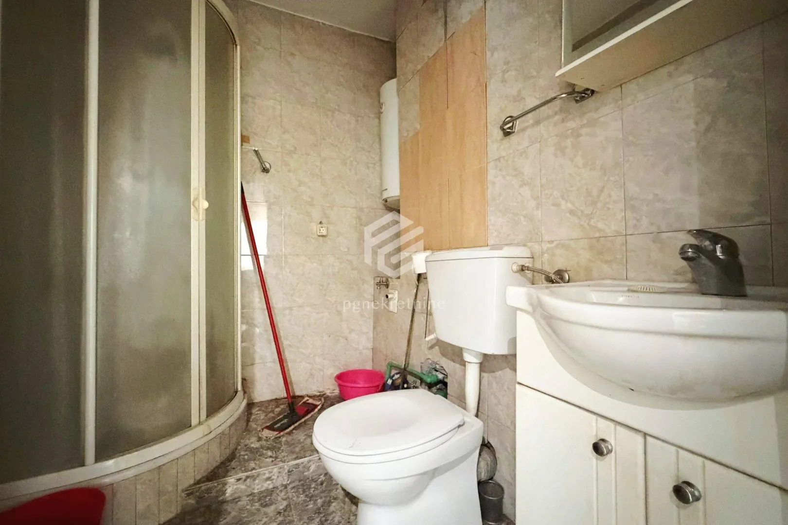 Manje kupatilo sa tuš kabinom, umivaonikom i wc šoljom.