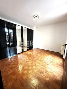 Empty room with parquet flooring and a large built-in wardrobe with a mirror. - image 4
