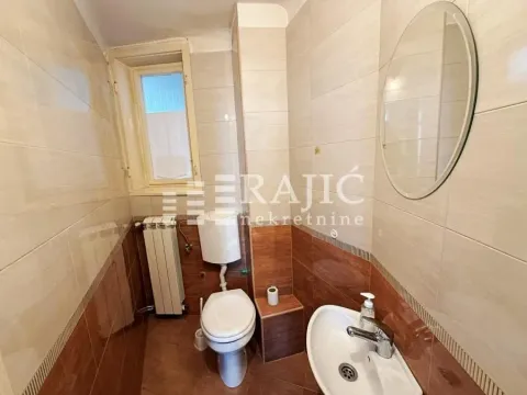 Smaller bathroom with a toilet, sink and mirror. - image 10
