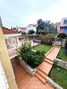 Pogled na uređeno dvorište i terasu kuće sa zelenilom. - image 9