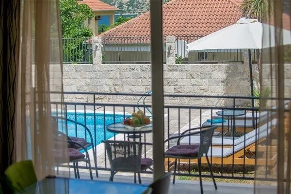 Pogled sa balkona na bazen i prostor za opuštanje.