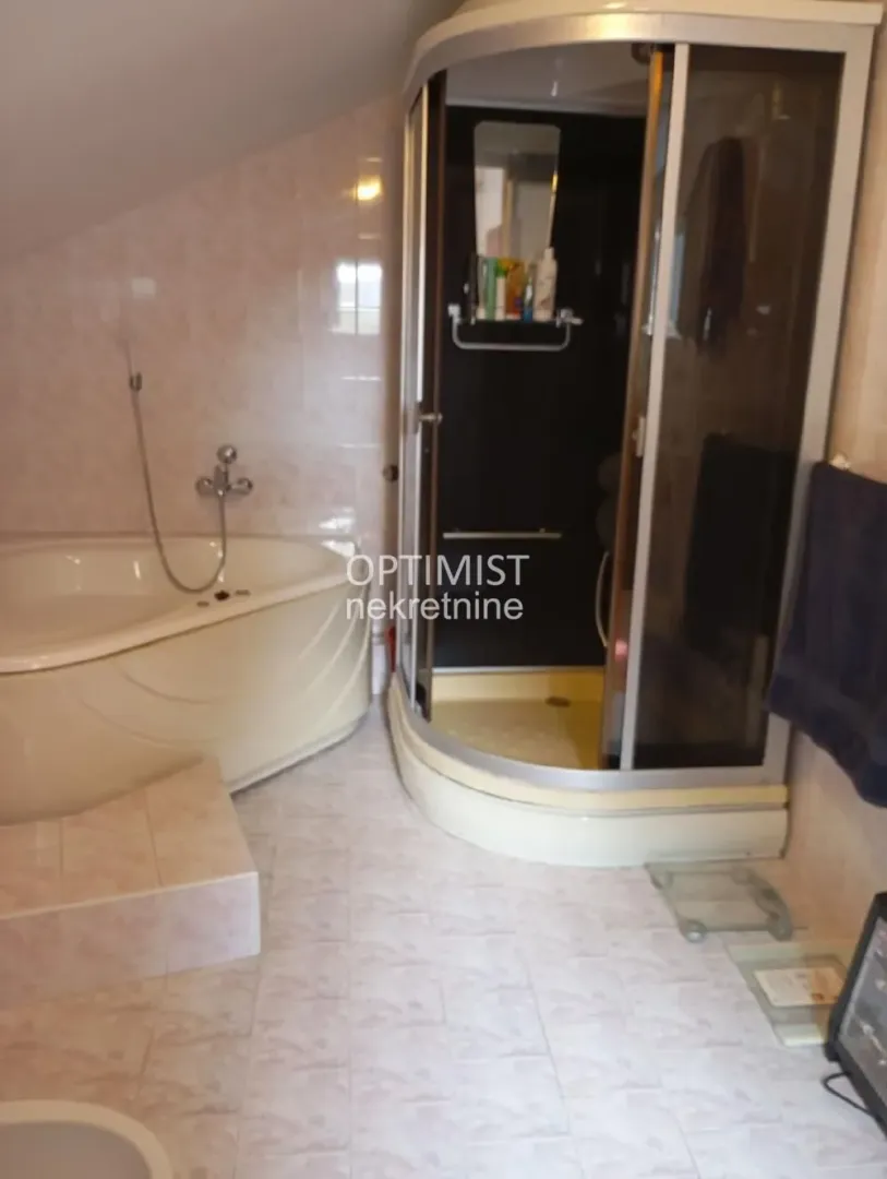 Bathroom with a bathtub and a shower cabin.