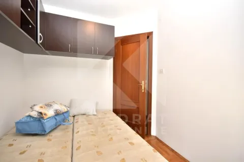 Small bedroom with a bed, wall cabinets, and a wooden door. - image 7