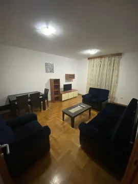 Living room with dark blue sofas and a dining area. - image 2
