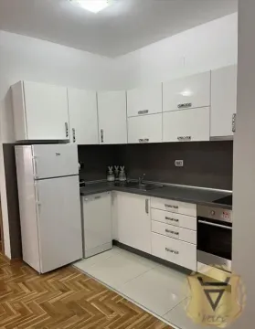 Manja bela kuhinja sa ugradnim elementima i frižiderom. - image 3