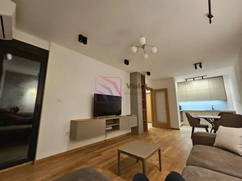 Dnevni boravak sa garniturom, televizorom i pogledom na kuhinju sa trpezarijom. - image 4