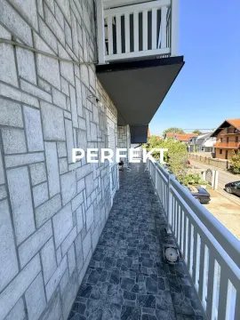 Dugačak popločani balkon sa belom ogradom i pogledom na ulicu. - image 17