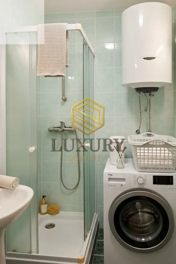 Bathroom with a shower cabin and a washing machine.