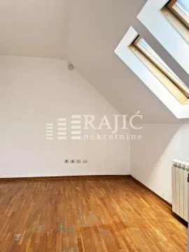 Empty room with parquet flooring and a skylight. - image 3