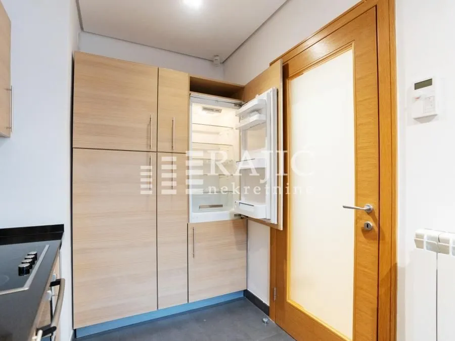 Modern kitchen with built-in cabinetry and an open refrigerator.