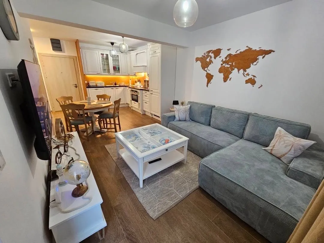 Living room with a sofa and a view towards the dining area and kitchen.