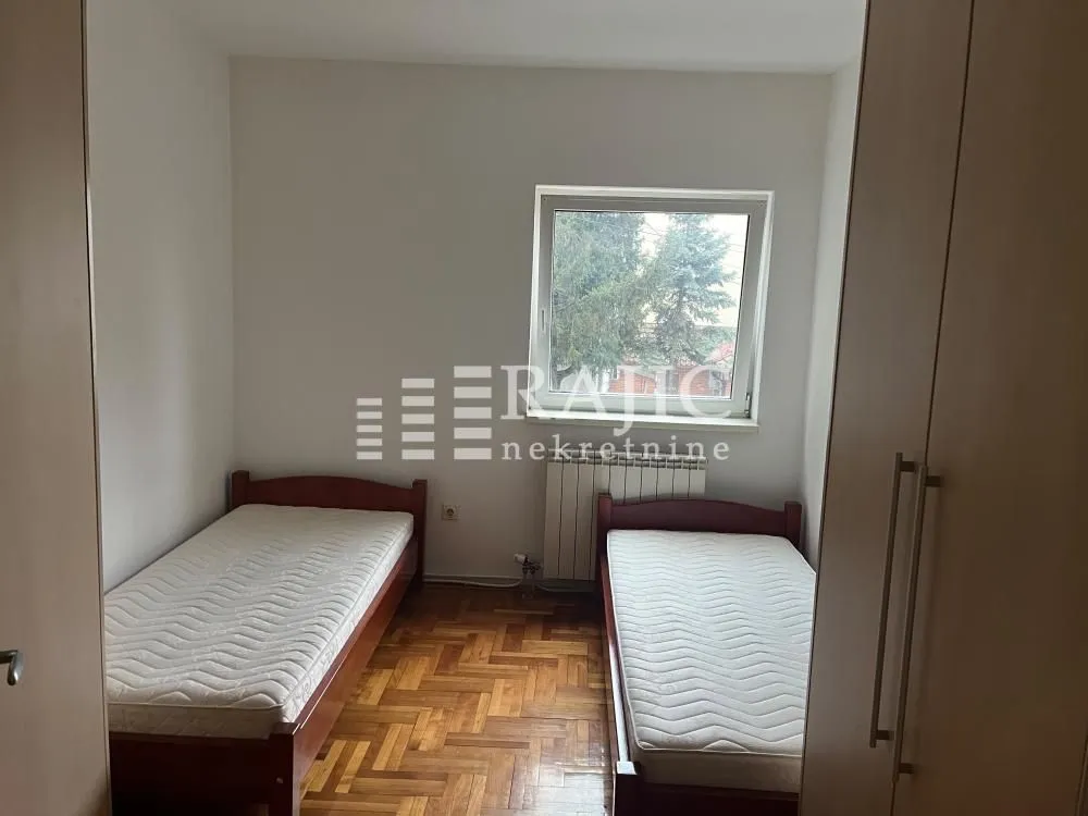 Twin bedroom with two single beds and wooden flooring.
