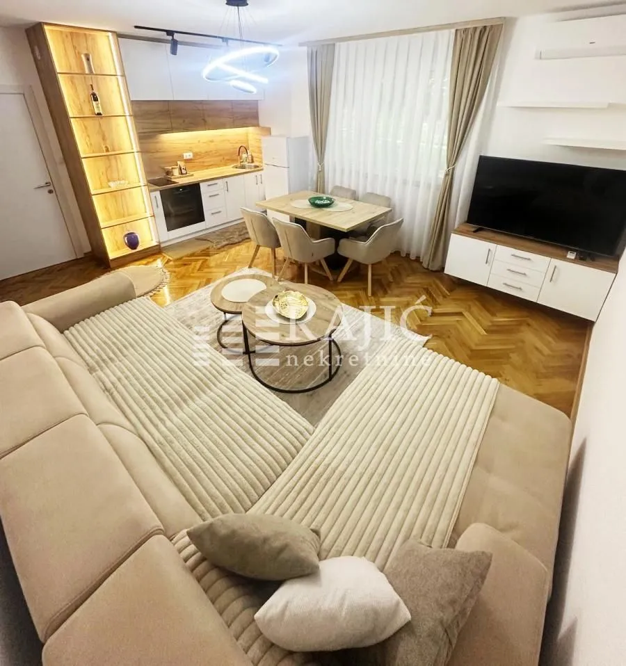Modern and bright living room with a dining area and kitchen in the background.