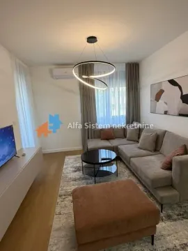Udobna dnevna soba sa ugaonom garniturom, stočićem i modernim lusterom. - image 3