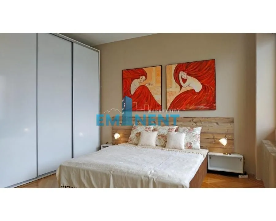 Furnished bedroom with a double bed, wardrobe, and artwork on the wall.