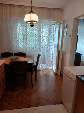Trpezarija sa drvenim stolom i stolicama blizu kuhinje i izlaza na terasu. - image 8