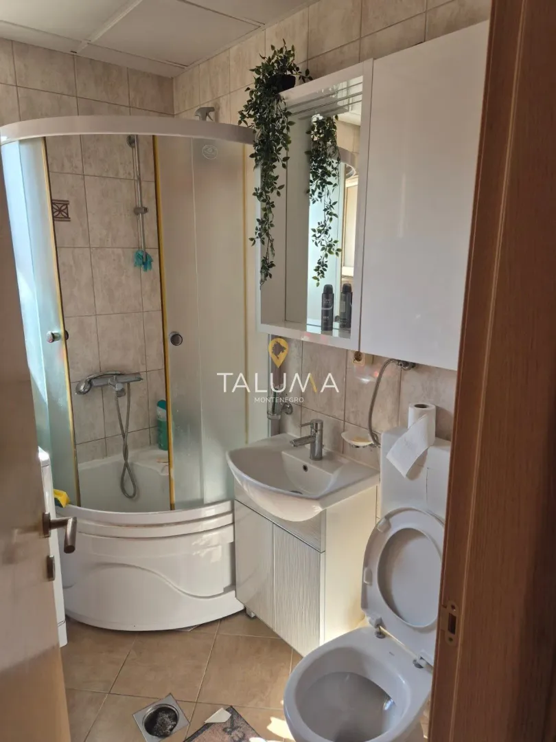 Kupatilo opremljeno tuš kabinom, umivaonikom i WC šoljom.