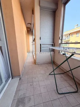 Spacious tiled terrace with a clothes drying rack and a view of surrounding buildings. - image 13