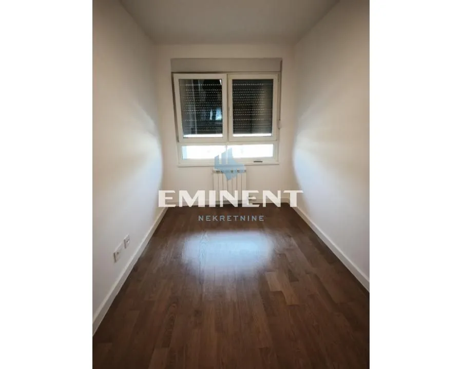 Empty room with hardwood floors and a window.