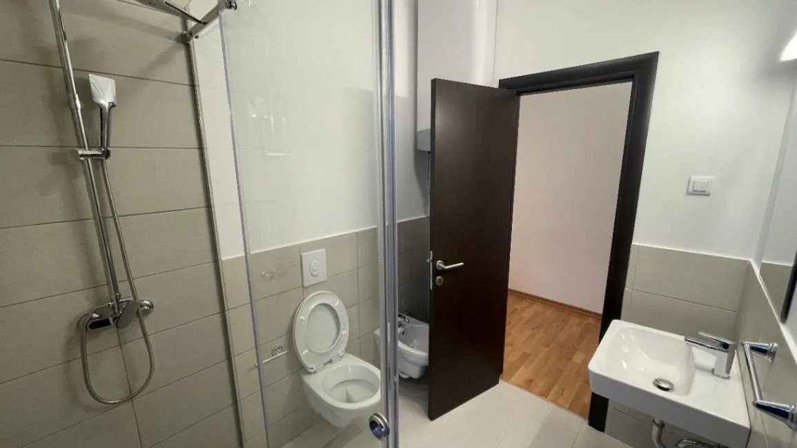 Moderne kupatilo sa tuš kabinom, umivaonikom i WC šoljom.