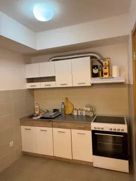 Small kitchen with white cabinets, sink, and electric stove. - image 3