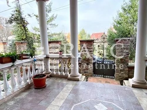 Covered terrace with columns and a view of the yard.