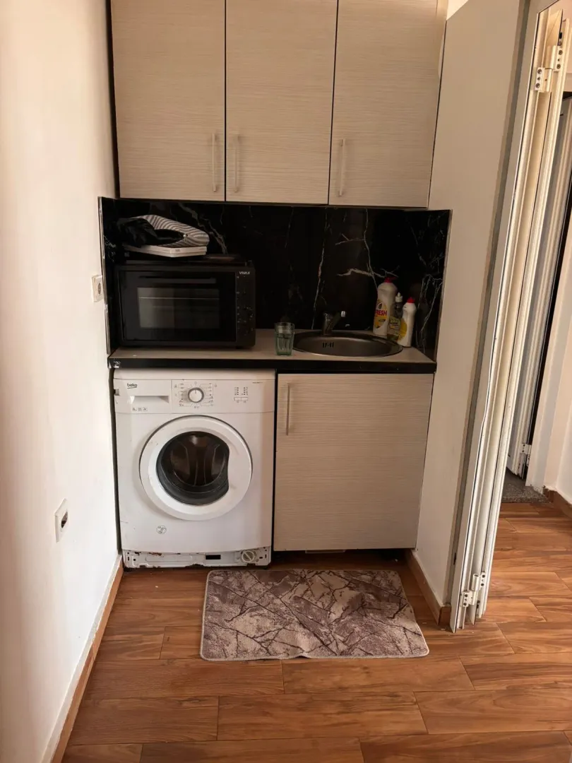 Small kitchen with a built-in washing machine and sink.