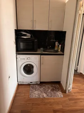 Small kitchen with a built-in washing machine and sink. - image 9