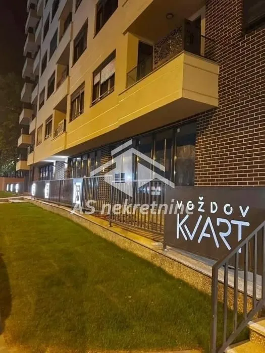Exterior of the residential building with a landscaped lawn and balcony.