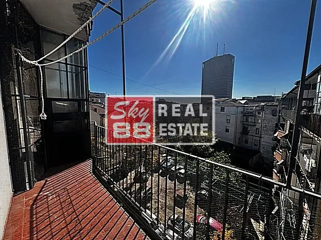 Balcony with a metal railing and city view.