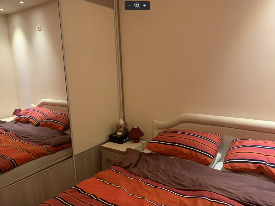 Bedroom with a double bed and a built-in wardrobe with a mirror.