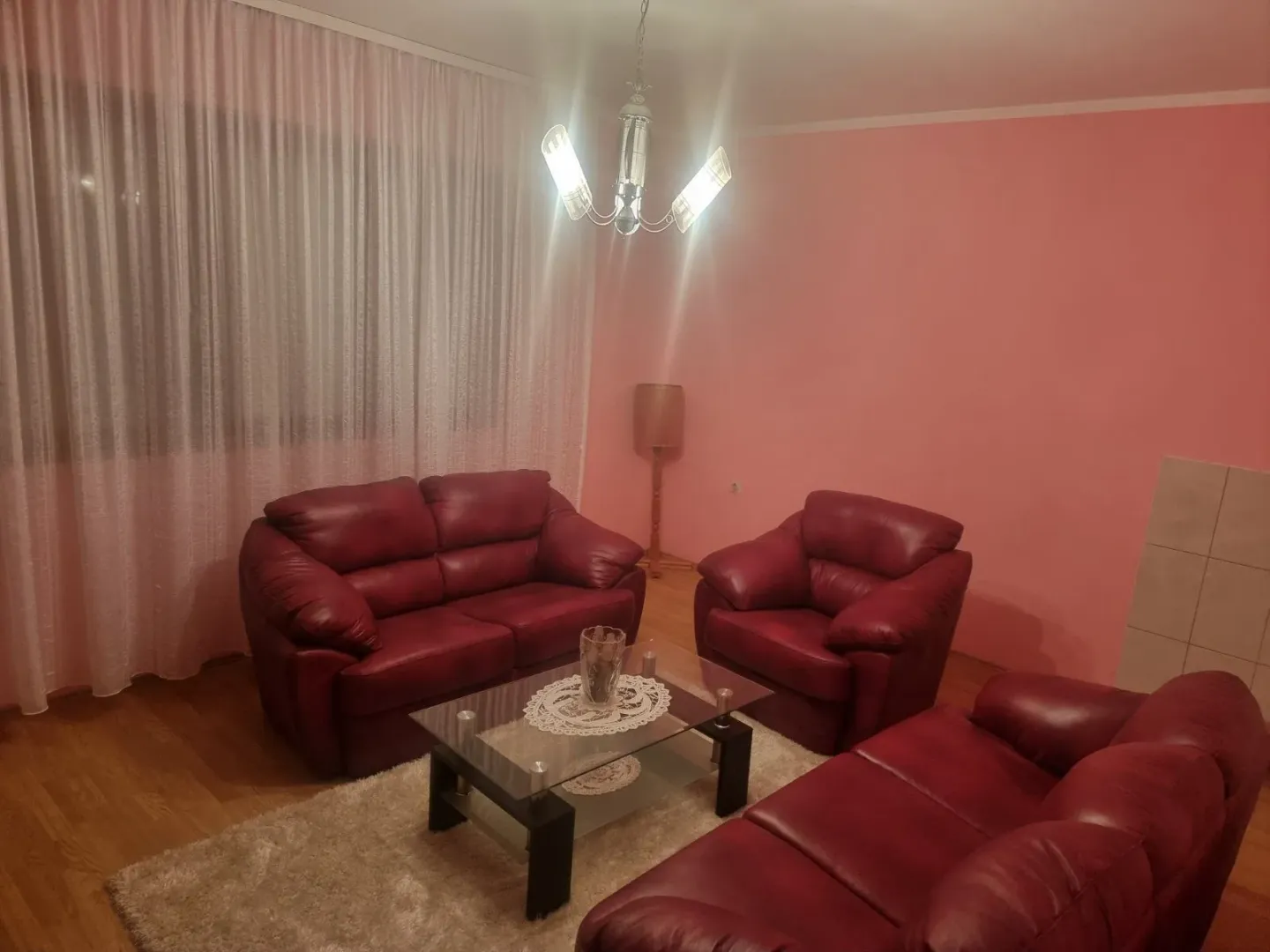 Dnevna soba sa garniturom od crvene kože i stočićem.