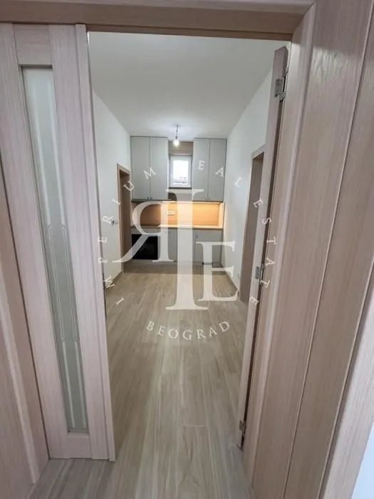 View from the hallway into the new kitchen with white cabinetry.
