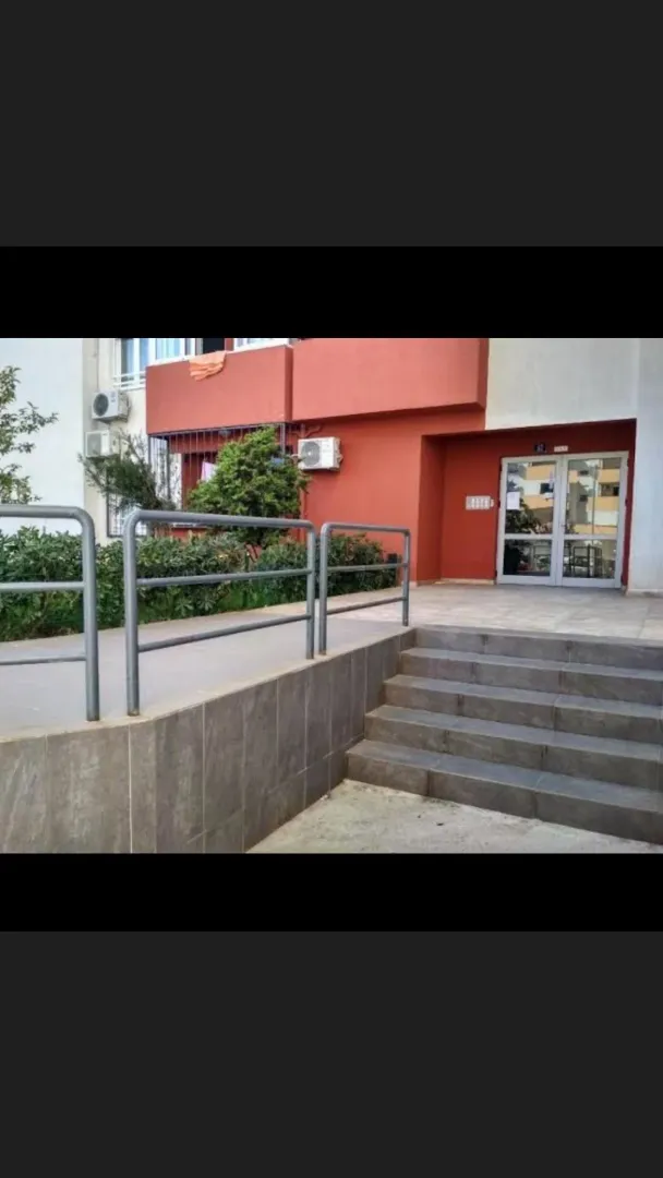 Ulaz u zgradu sa stepeništem i rampom za pristup.
