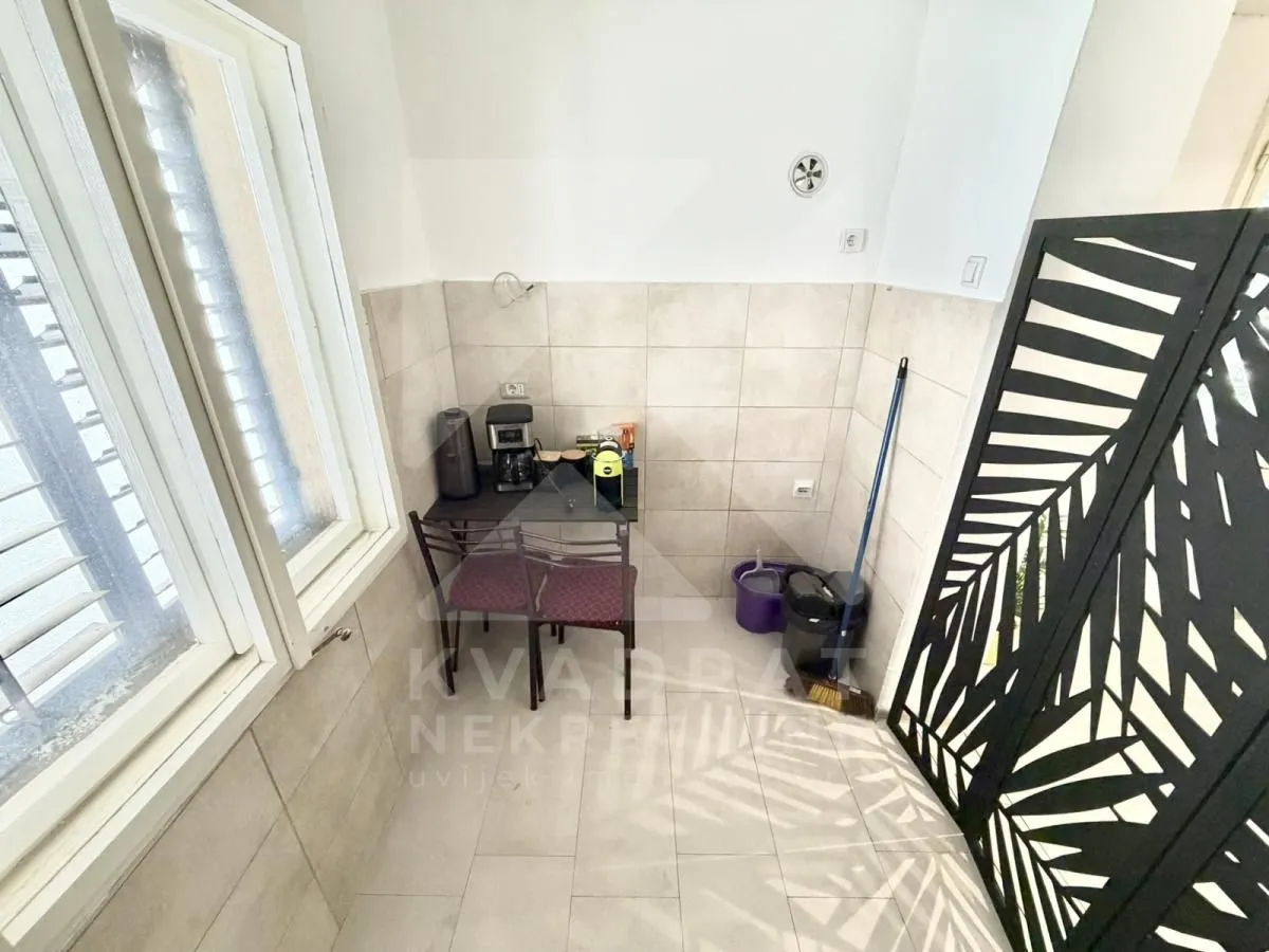 Small kitchen with wall tiles and a small table with chairs.