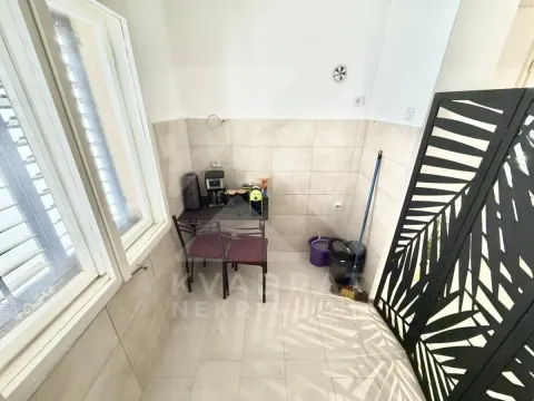 Small kitchen with wall tiles and a small table with chairs. - image 7