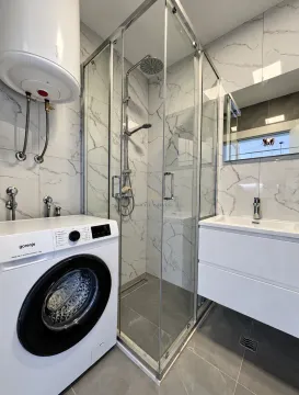 Moderno opremljeno kupatilo sa tuš kabinom, umivaonikom i veš mašinom. - image 6