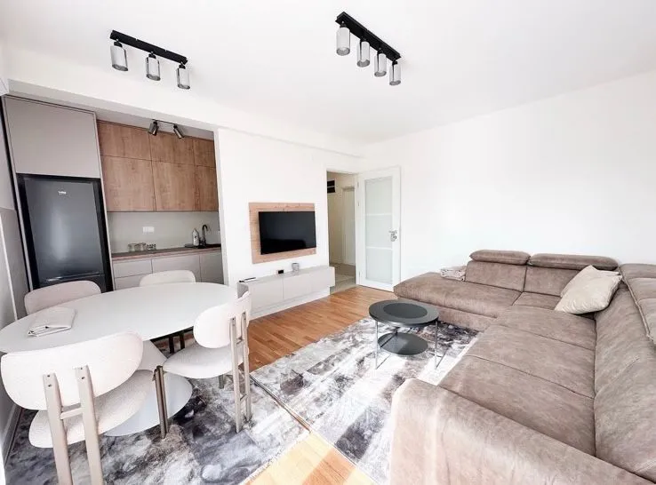Living room with a sofa set, dining area, and fitted kitchen.