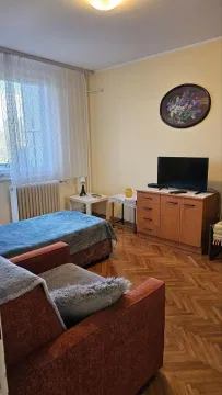 Furnished bedroom with a bed, an armchair, and a chest of drawers with a TV. - image 2