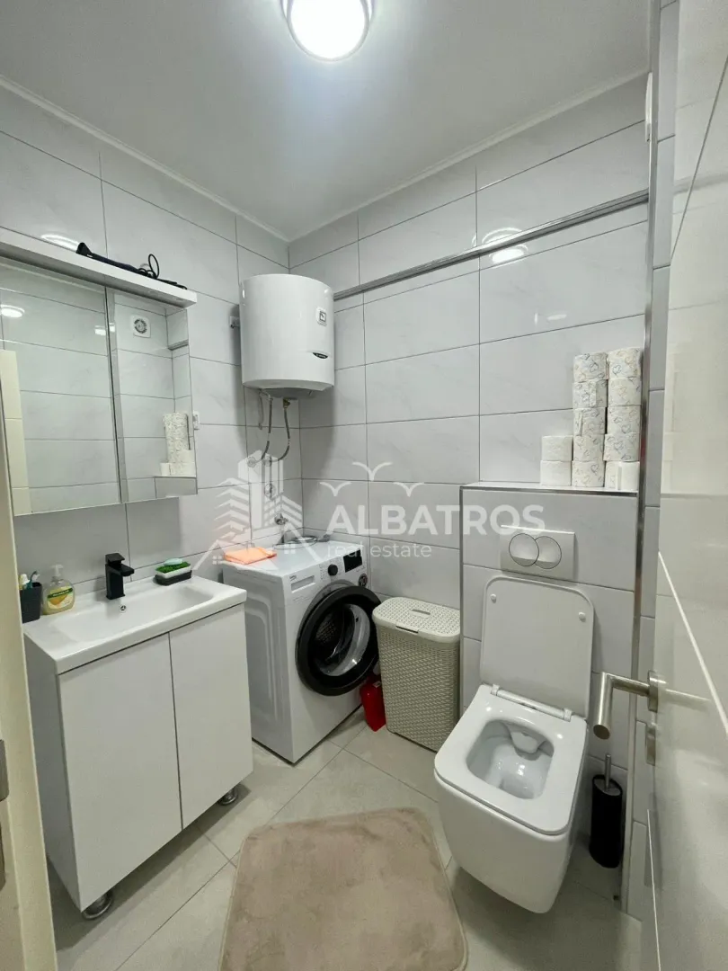 Bathroom equipped with a washbasin, washing machine, and toilet.