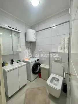 Bathroom equipped with a washbasin, washing machine, and toilet. - image 7