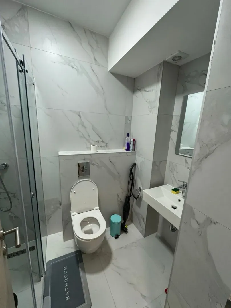 Moderne opremljeno kupatilo sa tuš kabinom, WC šoljom i umivaonikom.