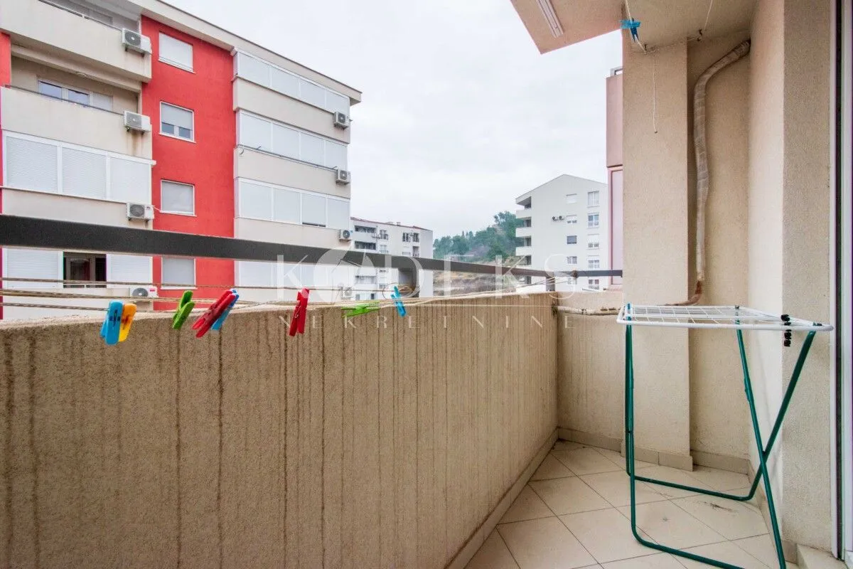 Balcony with a clothes drying rack and a view of neighboring buildings.