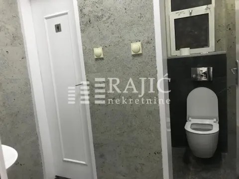 Modern bathroom with a toilet and gray wall tiles. - image 14